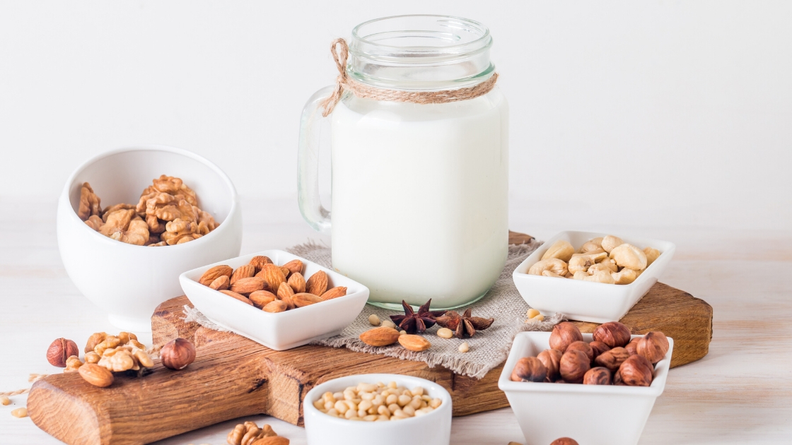 Nut milk in a bottle with many nuts around