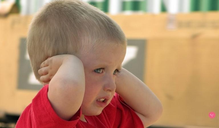 frightened child closing his ears